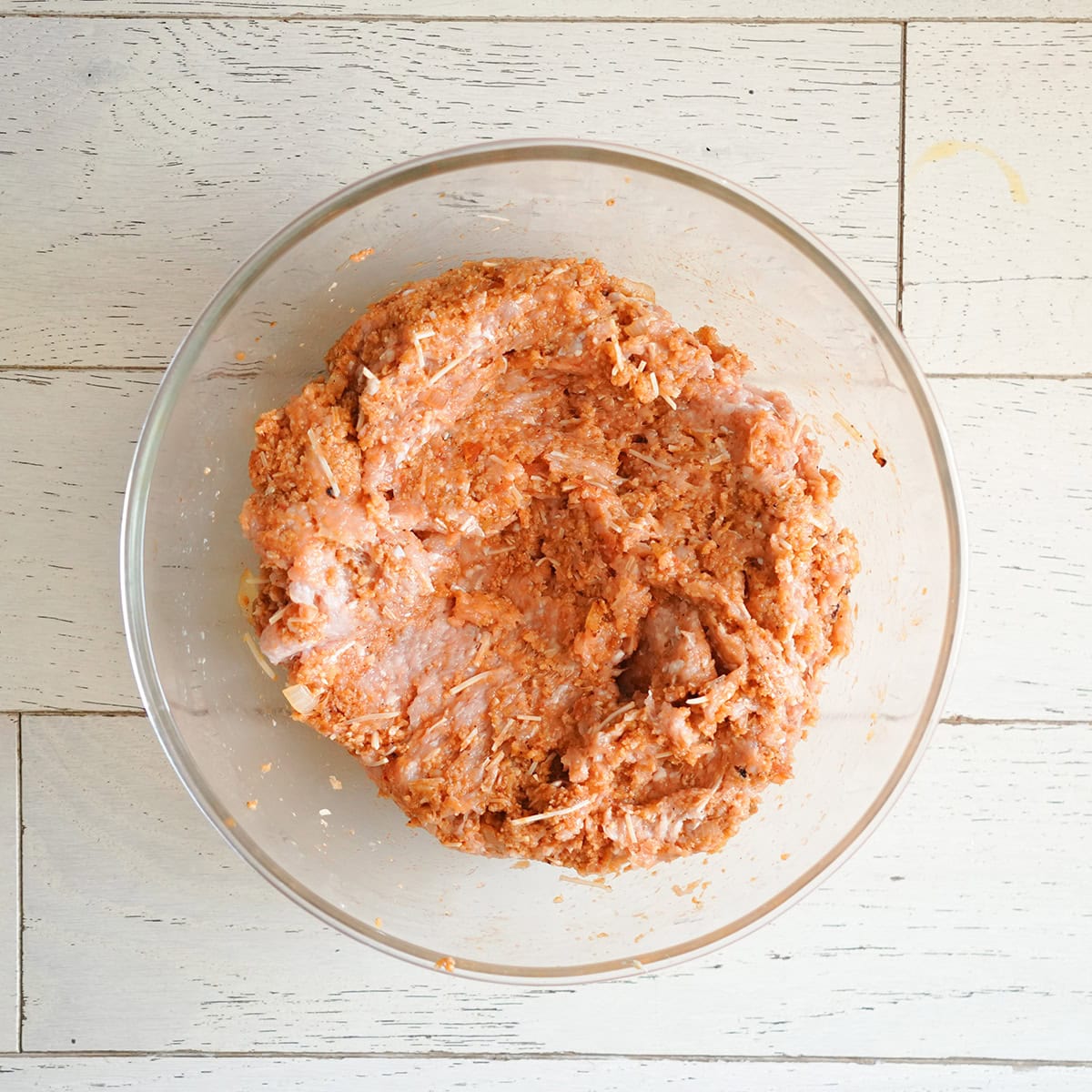 ground chicken mixed with seasonings for meatloaf.