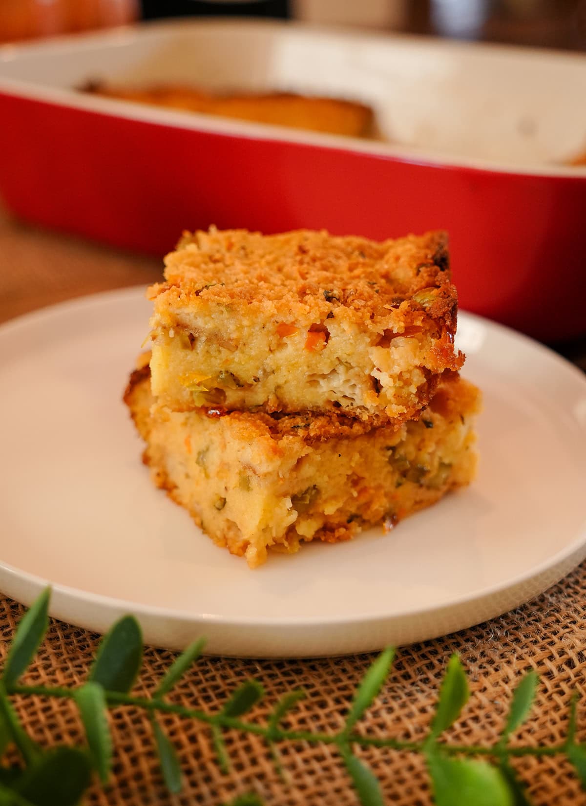 Cornbread dressing cut into squares on a plate.