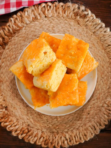 pieces of cheesy cornbread on a serving plate.