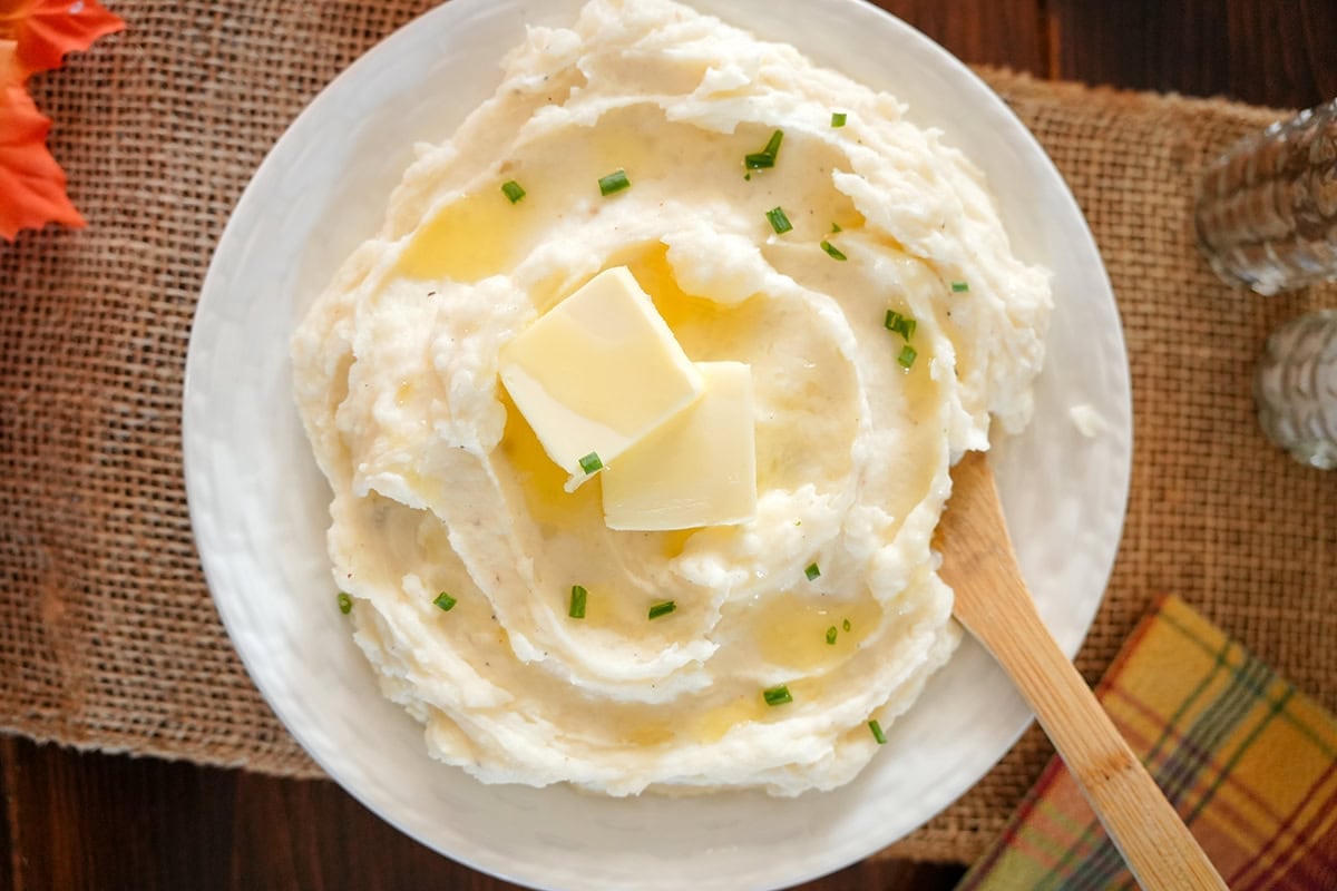 mashed potatoes in a bowl next to fall decor.