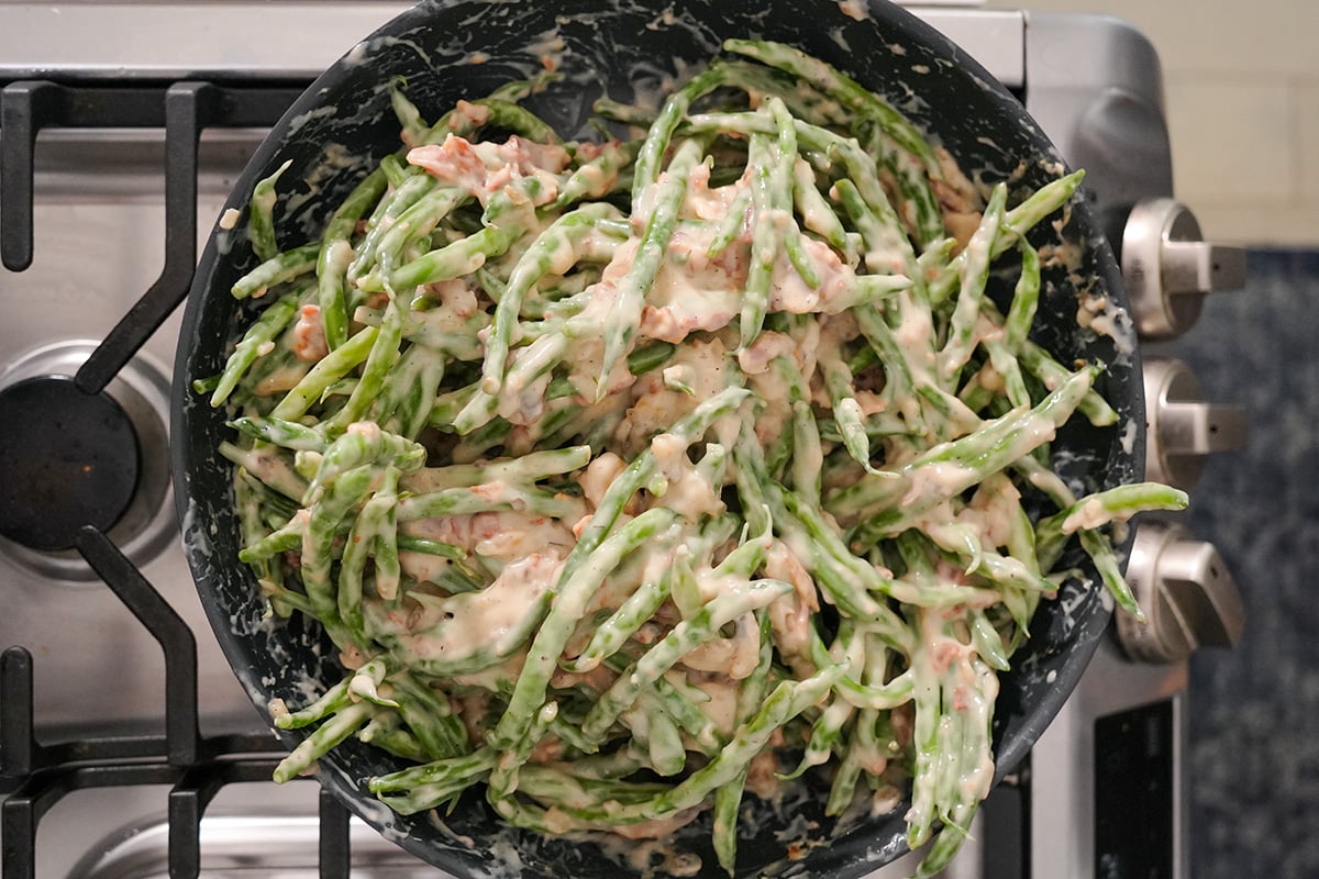 green beans mixed with a cream sauce in a skillet.