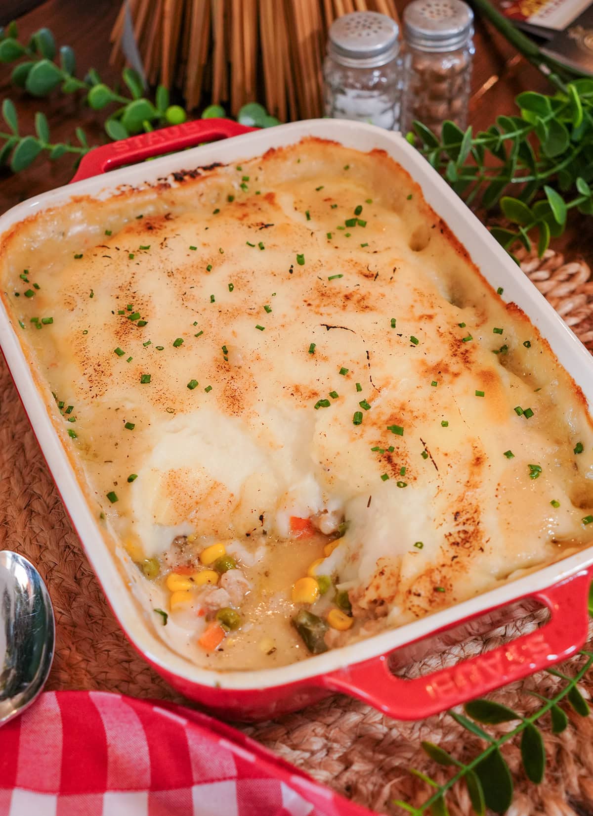 chicken shepherds pie with a scoop missing showing vegetables.