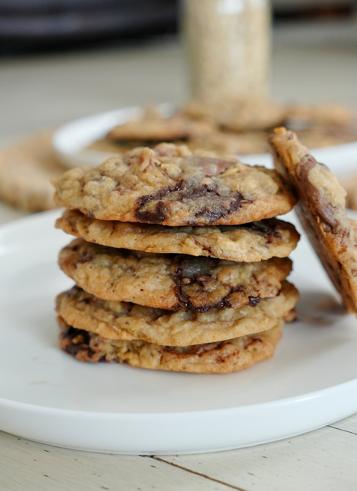 cookies stacked on a plate with chocolate chunks and oats.